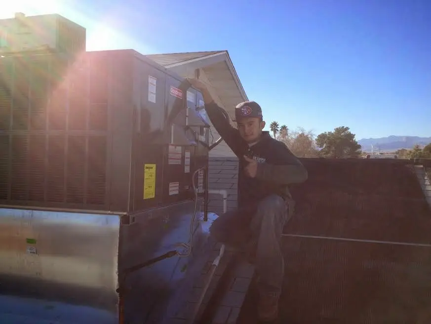 HVAC technician performing AC Tune-Up on a rooftop unit in Wright